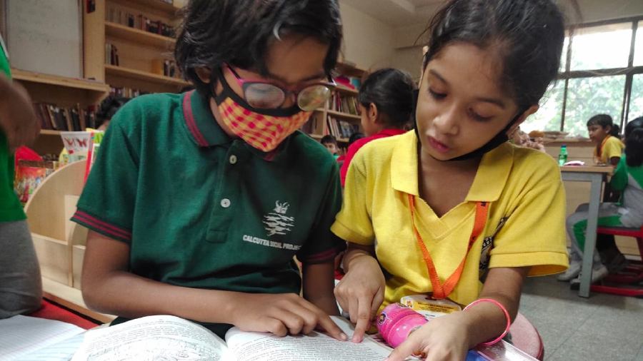 Hibah Ahmed of Class III reads out a story to a student of Calcutta Social Project