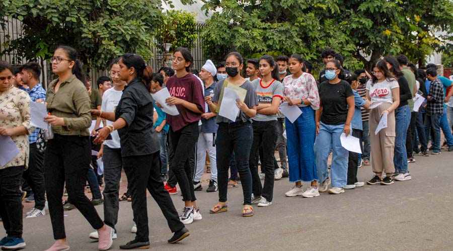 Students wait in a queue to appear in Common University Entrance Test (CUET), outside a centre, in Noida.
