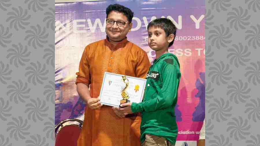 International Master Arghyadip Das gives a prize to the best under-12 player of the tournament Shreyas Ghosal