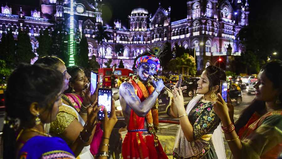  A boy dressed as Lord Krishna poses for a photo outside Chhatrapati Shivaji Maharaj terminus in Mumbai