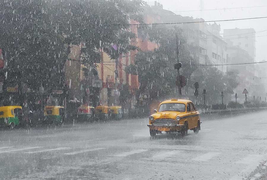A taxi negotiates its way through heavy rain near Girish Park on Friday.