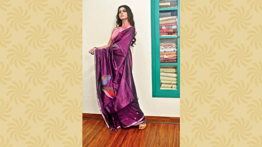 The model is wearing a handwoven pure silk sari in rich plum colour and embellished with jamdani motifs. Price: Rs 13,600