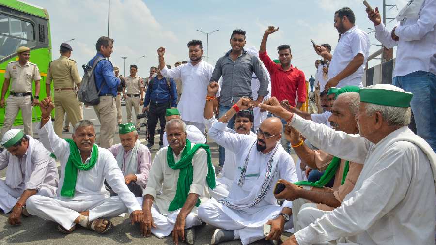 United Kisan Morcha members sit on a dharna after they were stopped by police on their way to take part in the protest