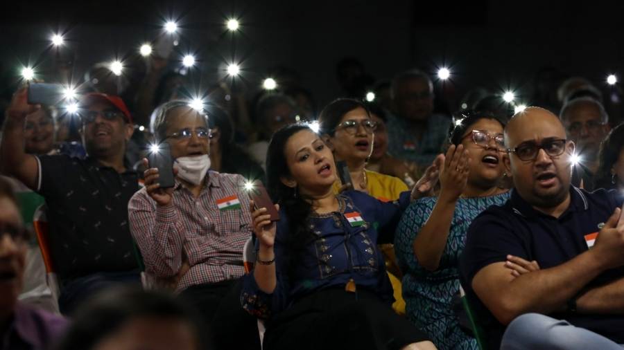 The audience holds up mobile phone torchlights and sings along to ‘Dhono dhanyo pushpe bhora’