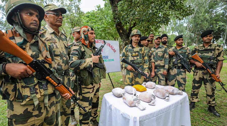 Border Security Force (BSF) personnel display eight packets of narcotics, suspected to be heroin, recovered during a search operation, in Samba, Thursday, Aug. 25, 2022. The troops shot at a Pakistani intruder foiling a bid to smuggle narcotics from across the border in the early hours of Thursday. 