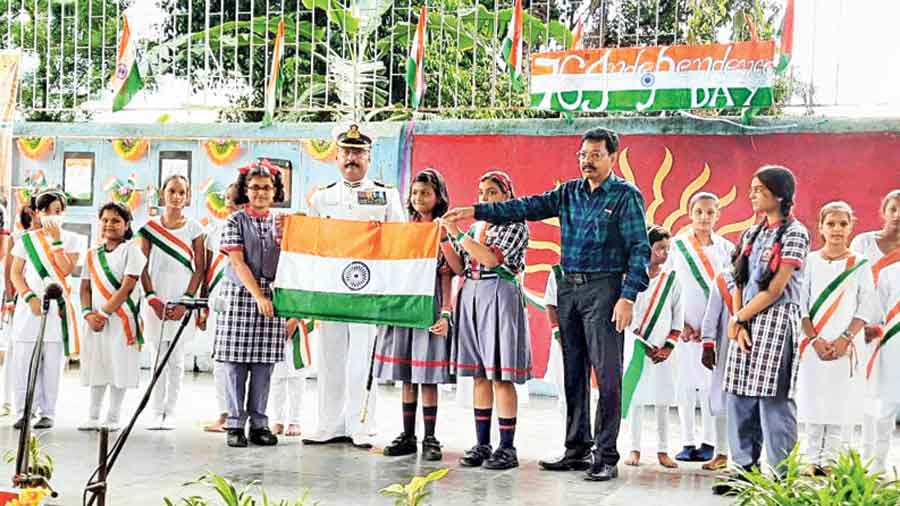 Commanding officer of the Indian Coast Guard, Calcutta, Avijit Dasgupta holds the Tricolour up with students 
