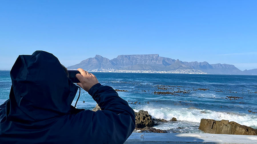 A tourist snaps a picture of the Cape Town coastline, as seen from Robben Island