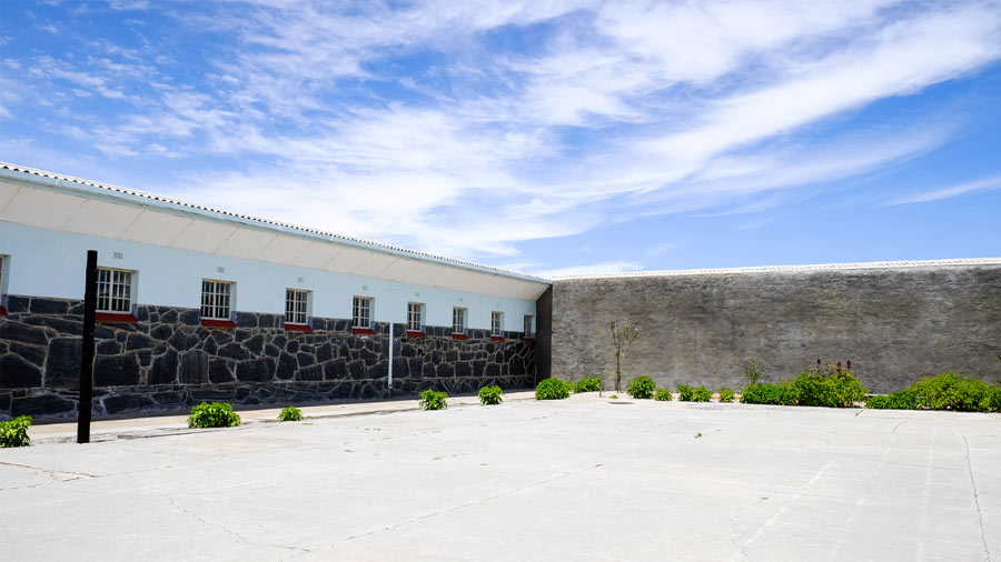 The prison premises stands against the backdrop of a clear, blue sky