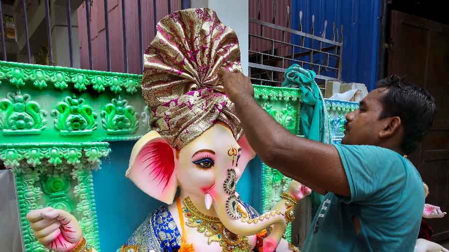An artisan gives final touches to an idol of Lord Ganesha ahead of the upcoming festival of Ganesh Chaturthi in Agartala