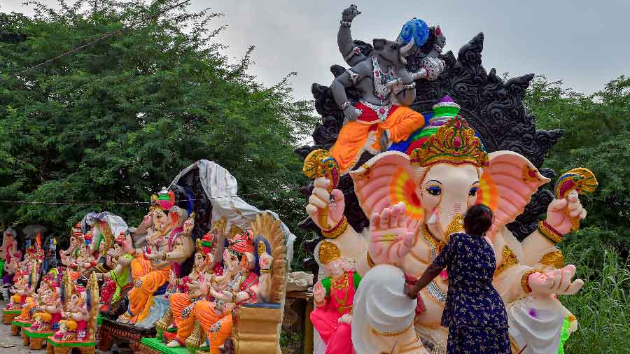 An artisan gives final touches to an idol of Lord Ganesha ahead of the upcoming festival of Ganesh Chaturthi, at a roadside stall in New Delhi