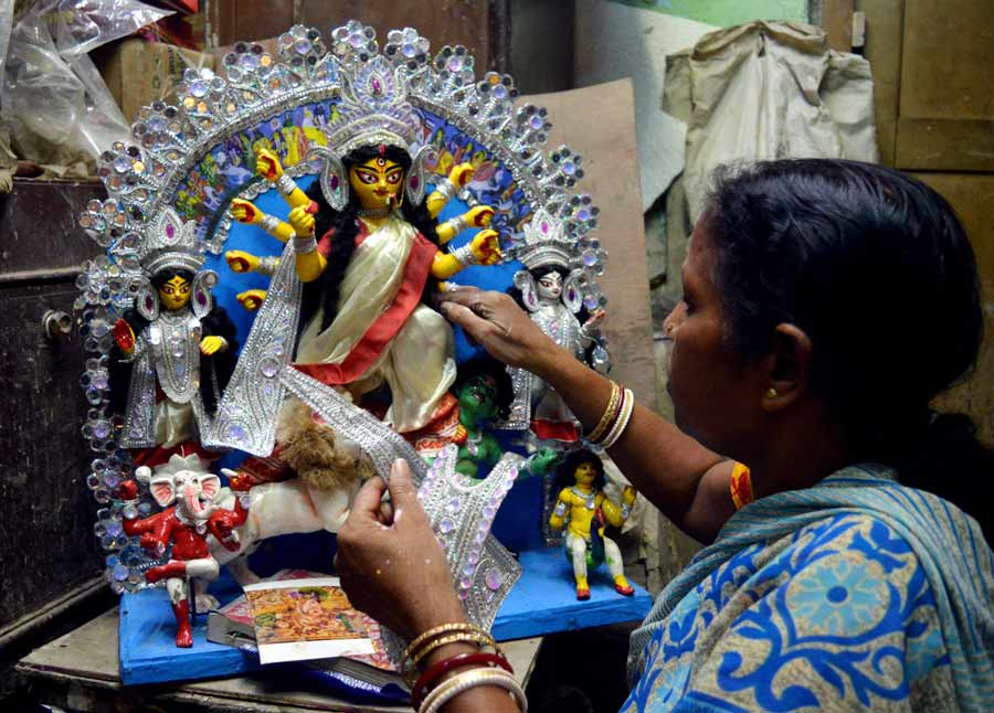 Artisan Mala Paul works on a miniature Durga idol at Kumartuli on Tuesday.