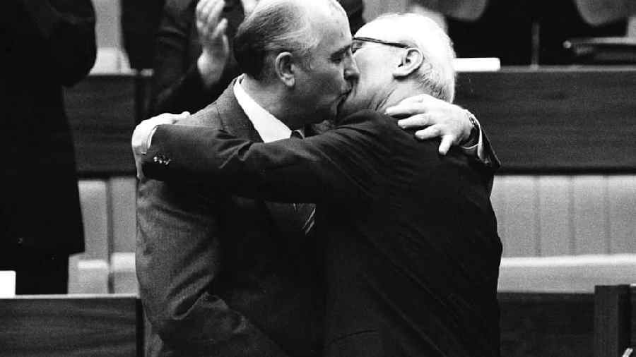 Mikhail Gorbachev embraces Erich Honecker with a congratulatory hug and kiss after the latter's re-election as General Secretary of the Communist Party Congress in East Berlin