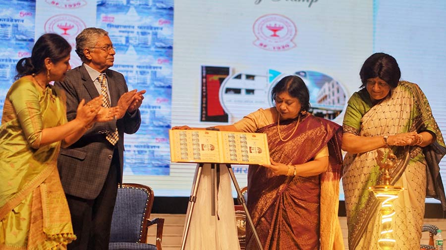 Justice Indira Banerjee and J. Charukesi unveil a postal stamp to mark 100 years of the Shikshayatan Foundation as Bratati Bhattacharyya, secretary general and CEO of Shikshayatan Foundation, and G.K. Khaitan, president of Shri Shikshayatan College, look on