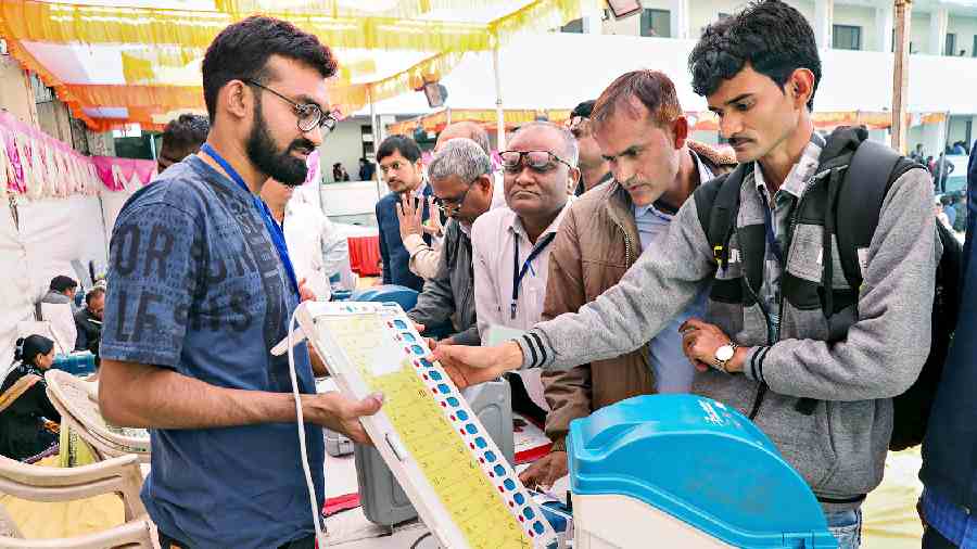 Polling officials collect EVMs and other election equipment in Rajkot before leaving for their respective polling stations on Wednesday, a day before the first phase of polling in Gujarat.  