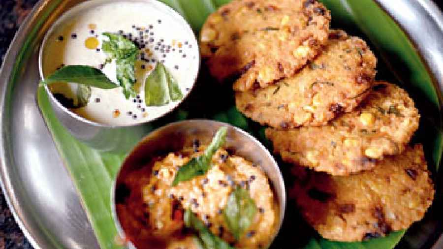 Shallow-fried Parappu Vada which is made with chana dal, coconut and other Indian spices and served with white and red chutney. Goes best as your evening snack.