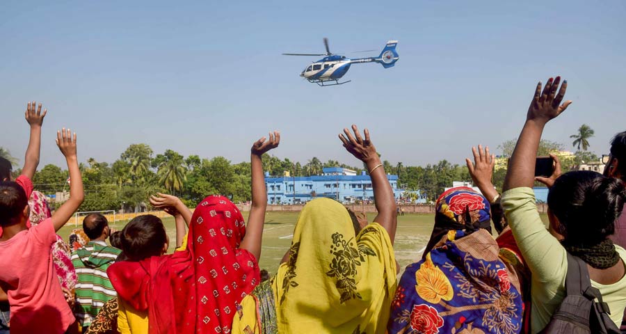 Villagers wave at a helicopter carrying chief minister Mamata Banerjee as she leaves North 24-Parganas after her visit on Thursday