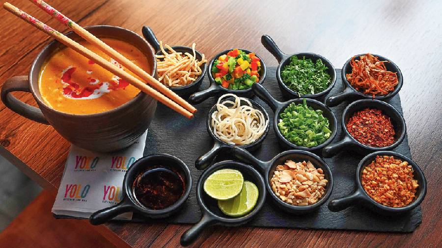 A little DIY platter for you, Khow Suey Burmese Noodle Soup served with an array of condiments like noodle crisps, caramelised onions, chilli oil, fried garlic, crushed peanuts, spring onions, and lemon wedges
