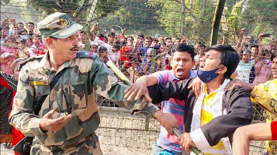 Indian villagers confront a BSF guard at Makorhat in North Dinajpur district on Friday. 