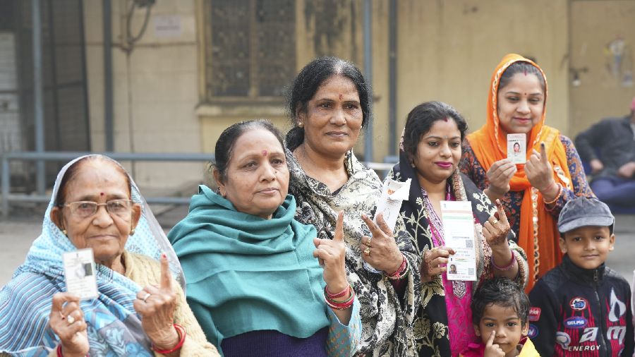 Voters show their fingers marked with indelible ink after casting votes for the Municipal Corporation of Delhi elections, at a polling station in Shahbad Daulatpur area. 