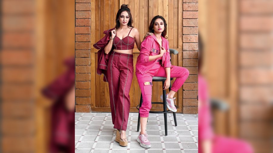 The velour tracksuit, a chosen leisurewear of the early 2000s that also symbolised status and purchasing power, regained favour of the fashionistas as the athleisure trend caught on post the pandemic. Widely popularised by Juicy Couture with celebs like Paris Hilton and Rihanna sporting them in the early 2000s, the tracksuit reigns supreme as a trend on the comeback Y2K trends list of this year. Bibriti sports a neon pink one from The Atrium-Westerns Multidesigner with the Y2K popular metallic detailing flashing on the pockets, adding a dose of glam.                Ayoshi channels the denim-on-denim trend in a maroon shade complementing Bibriti’s look in the frame. The contrast stitch cotton denim piece from The Atrium is a co-ord set of a bustier, straight pants and a puffed-sleeve jacket.