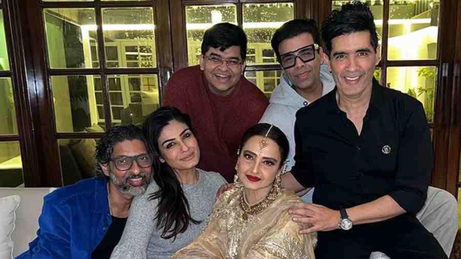 Filmmaker Karan Johar, veteran actress Rekha, Raveena and others pose with Manish for a group photo.