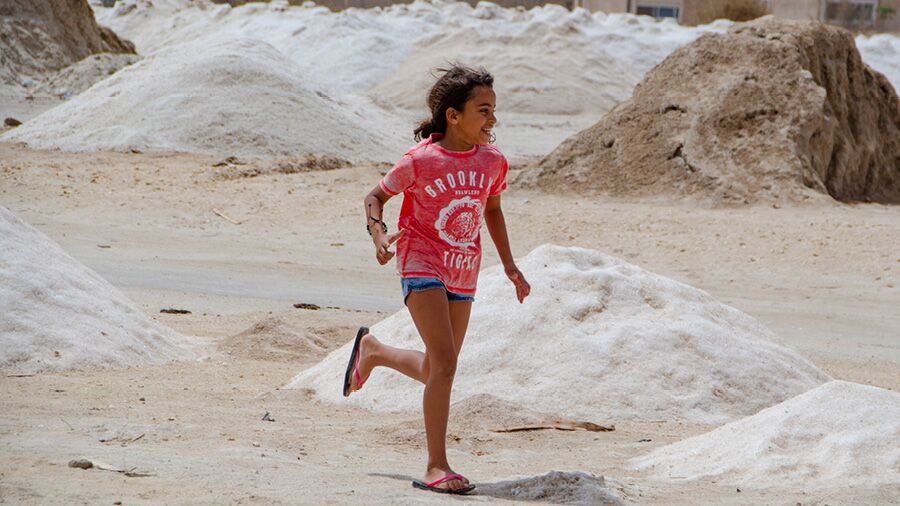 A child playing around the salt mounds