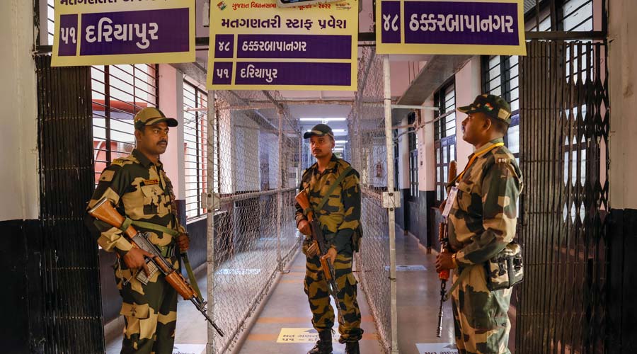 Border Security force (BSF) personnel stand guard at a strong room ahead of counting for the Gujarat Assembly elections in Ahmedabad.