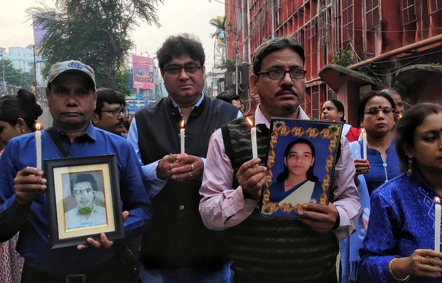 Family members of AMRI fire victims organised a candle march in memory of the victims from Dhakuria Lake to AMRI Hospital where they lit candles in front of the victims' photographs