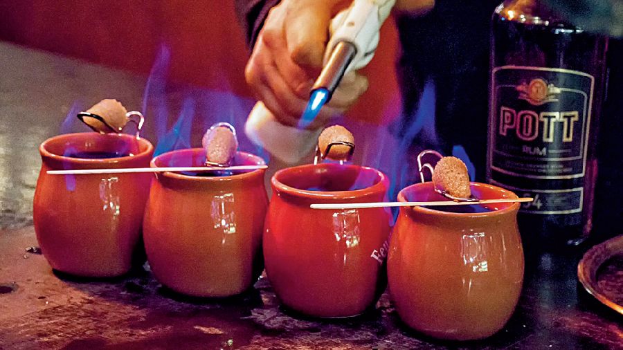 The Feuerzangenbowle drink of hot rum poured into red wine over a sugar crystal