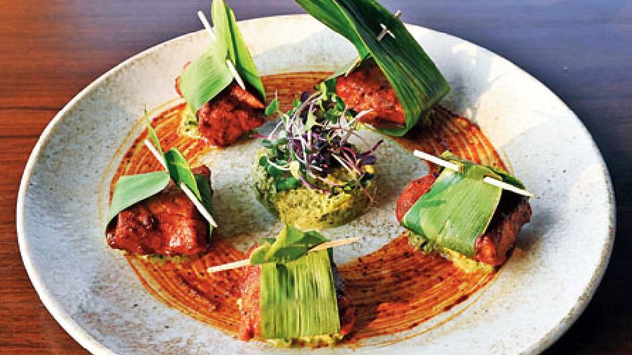 Ghee Roast Bhetki: A spicy fish starter that has ghee roast bhekti wrapped in banana leaf and served with raw mango chilli salsa