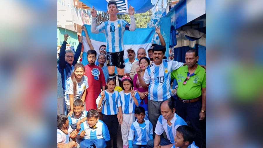 Argentina fans pose with a huge Messi model and the team's national flag near Shib Shankar Patra tea shop