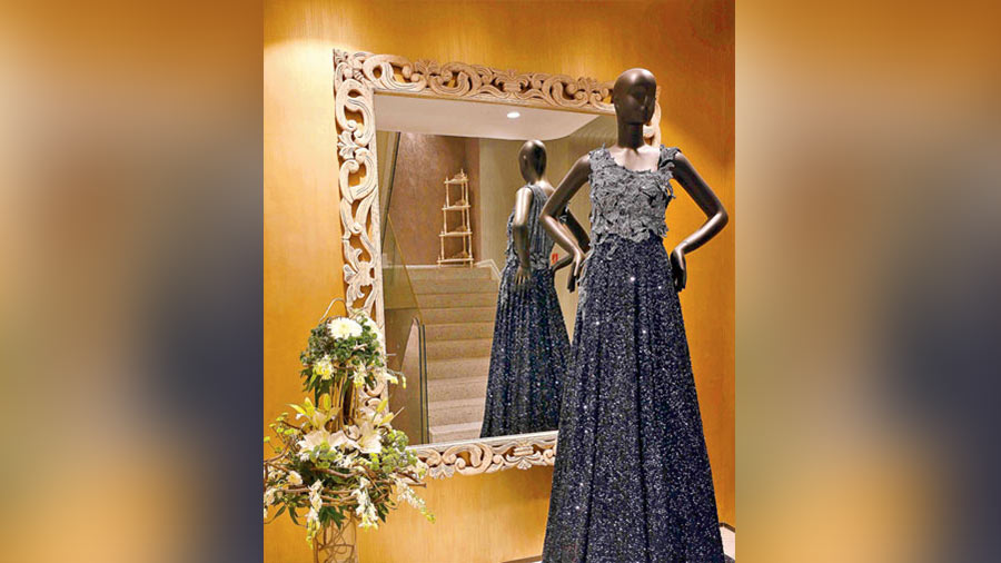 The second floor displaying gowns and lehngas showcases a collection of resham work, zardozi work, sequin work and wire detailing. This raw silk trail gown features floral applique and is embellished with sequins and cutdana.