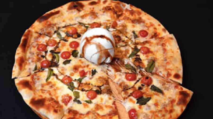 Burrata Pizza: This hand- rolled, thin-crust pizza will  have you going back for more slices especially when you have it with the fresh and creamy burrata cheese. (Rs 950)