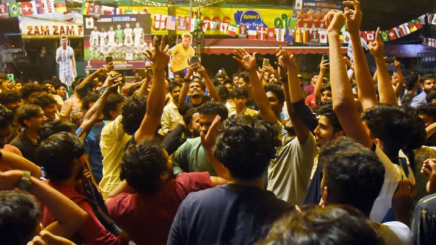 Football fans dance on the street.