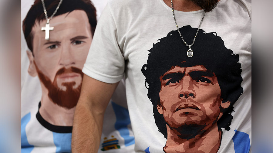 Fans wear t-shirts with the faces of Messi and Maradona in Doha 