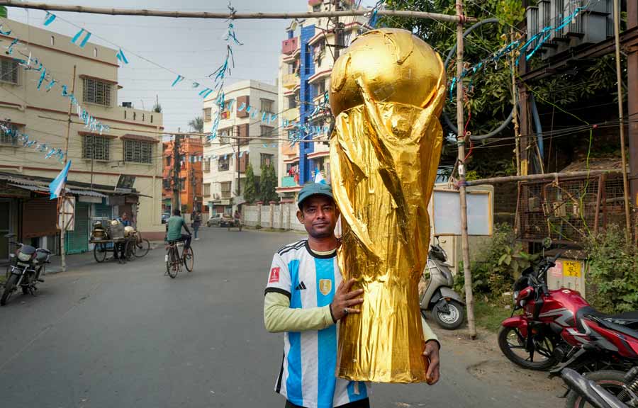An Argentina supporter flaunts a giant size model of the trophy on Sunday evening before the high-octane match