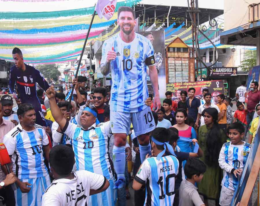 Fans clad in Argentina jerseys carry a large cutout of Messi. Mbappe is not left behind either, as France fans proudly carry his cutout (extreme left) 
