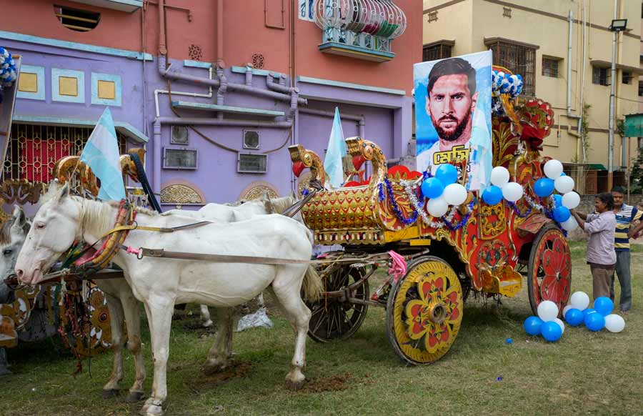 Argentina soccer fans prepare a horse cart with blue-white balloons and photographs of Lionel Messi before the start of their victory rally in Kolkata on Tuesday to celebrate the team's victory in the FIFA World Cup 2022