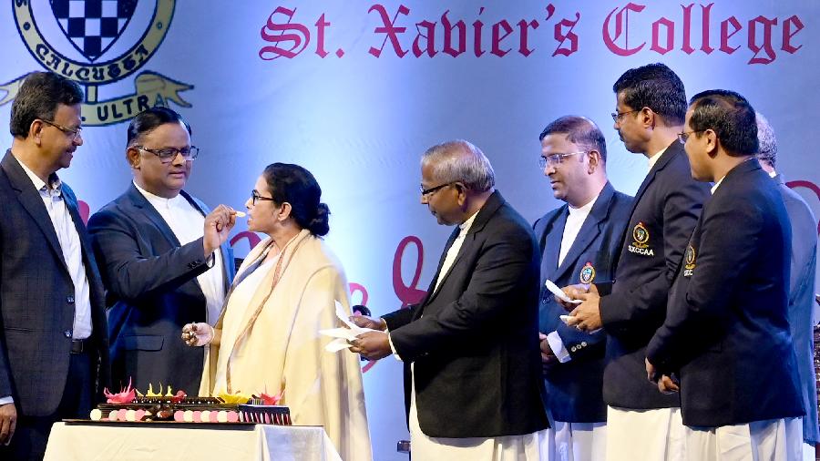 St Xavier’s College principal Father Dominic Savio offers cake to chief minister Mamata Banerjee as mayor Firhad Hakim (left) and St Xavier’s University vice-chancellor Father Felix Raj ( second from right) look on at St Xavier’s College, Park Street, on Wednesday evening