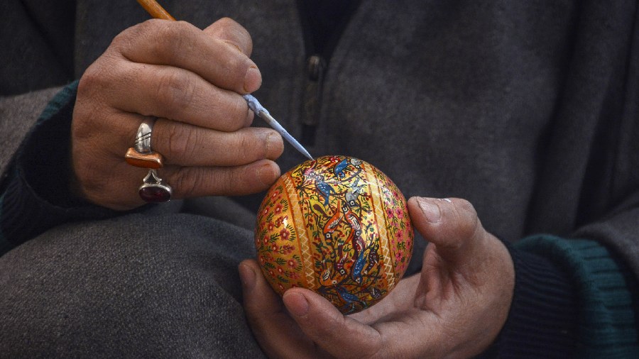 A Kashmiri artisan gives final touches to a Christmas decoration item at his workshop in Srinagar. 