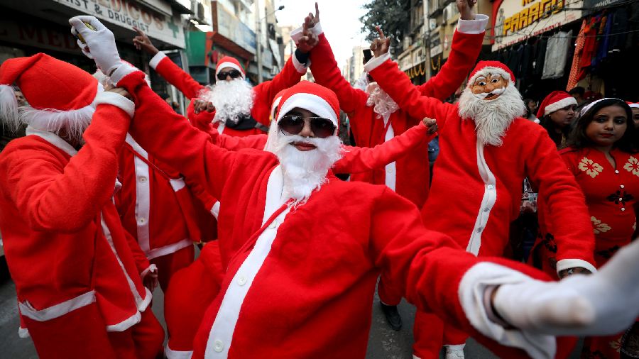 People dressed as Santa Claus take part in a procession during celebrations of Christmas festival, in Jammu. 