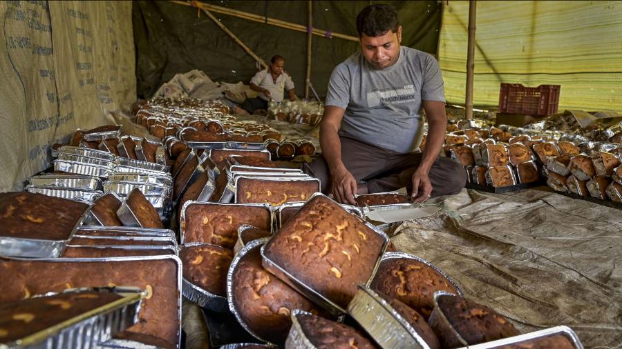 A worker packs cakes at a workshop as part of preparations for the upcoming festival of Christmas, in Nadia. 