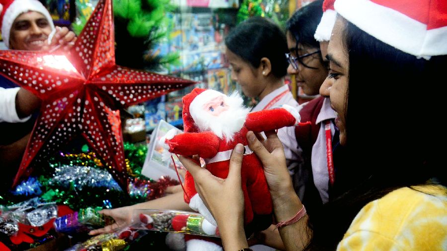 Customers look at decorative items at a shop ahead of Christmas, in Thane. 