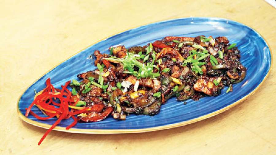 Chilli Pork: Succulent and juicy bite-sized pork chunks are cooked with salt and chilli powder, then stir-fried with ginger, garlic, soya sauce, chilli sauce, and veggies like onion, assorted capsicum and chillies. This is then seasoned with cracked peppercorns and garnished with spring onions. Rs 450