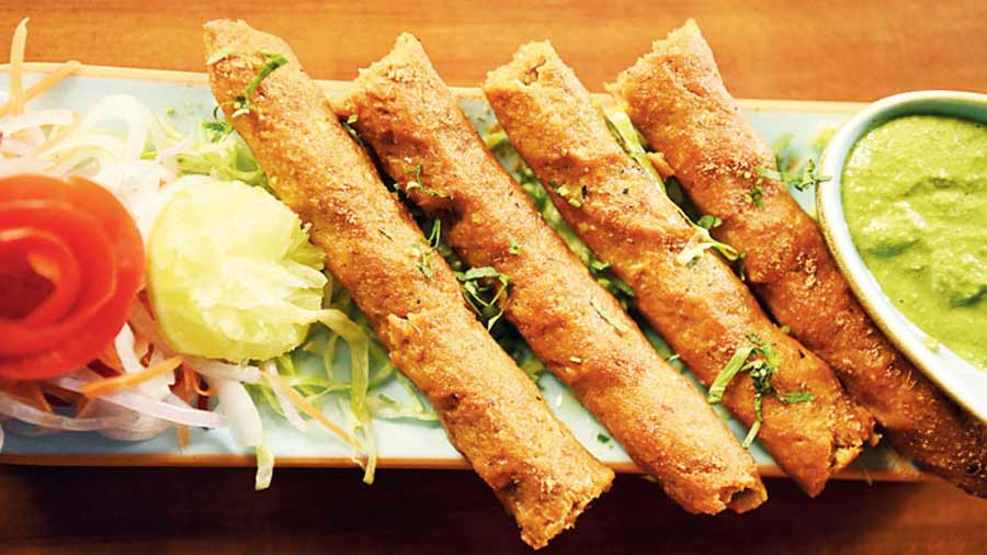 This Murgh Kakori Kebab is a blend of finely hand-minced lamb, saffron, rose petals and cardamom. It is served with salad and green chutney.