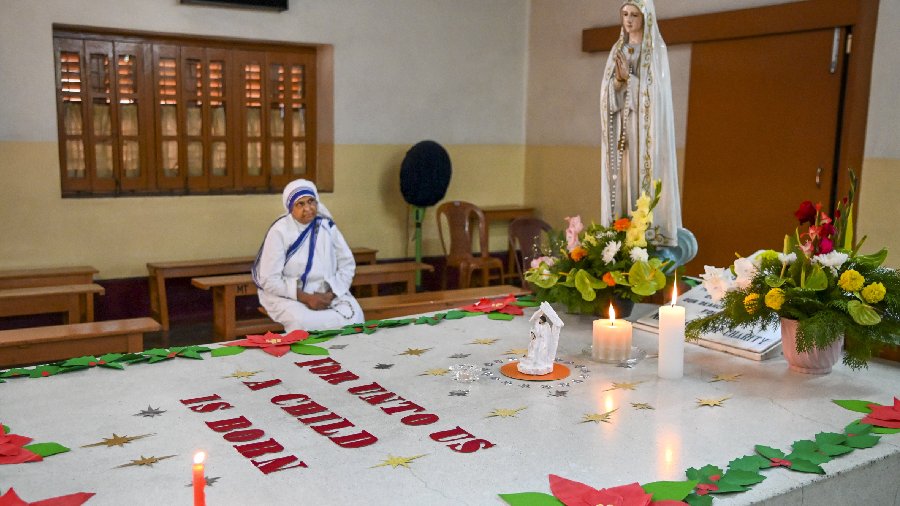 A nun offers prayers at Mother Teresa's tomb during Christmas celebrations at Mother House in Calcutta. 