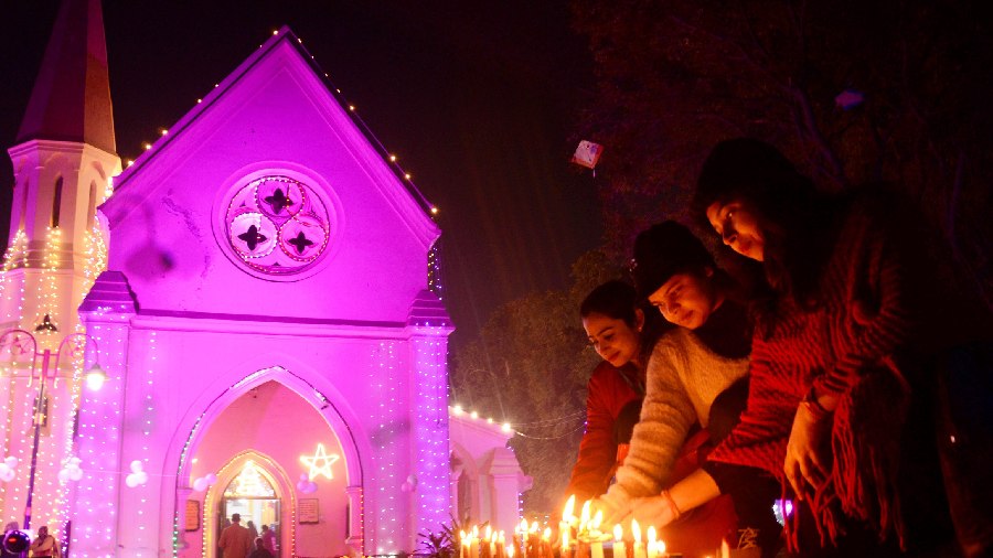 People light candles on the eve of Christmas at St Paul's Church, in Amritsar