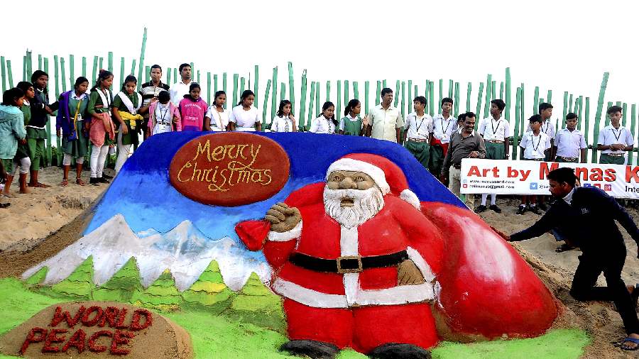 Sand artist Manas Kumar Sahoo makes a sand sculpture of Santa Claus in Puri. 