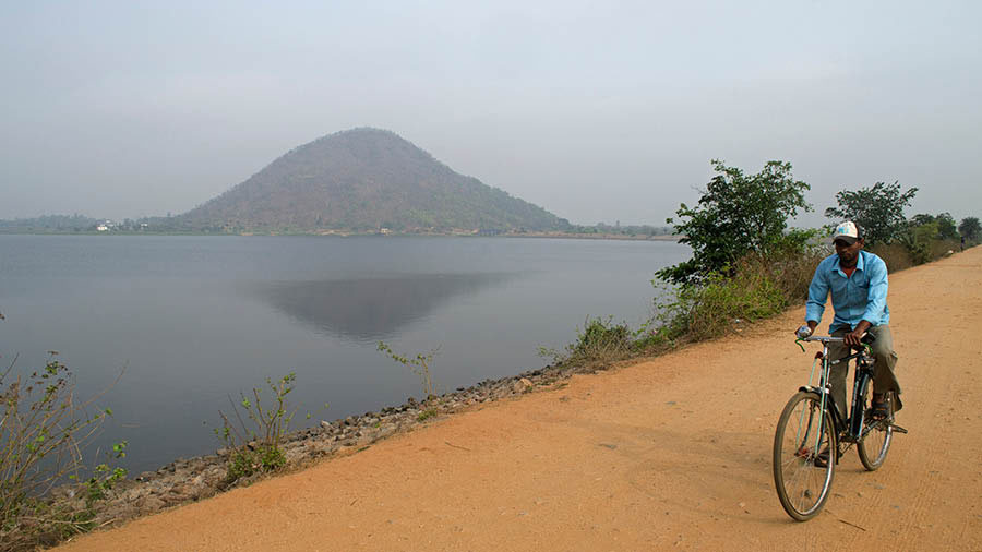 A cyclist rides along the embankment of Baranti lake 