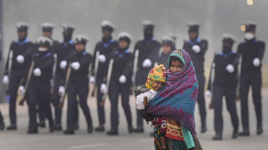 Across the northwestern plains, temperatures are expected to rise by about 2 degrees over the next three days. A labourer wrapped in woolens walks down the Kartavya Path as IAF personnel rehearse for the Republic Day function during a cold and foggy morning, in New Delhi. 